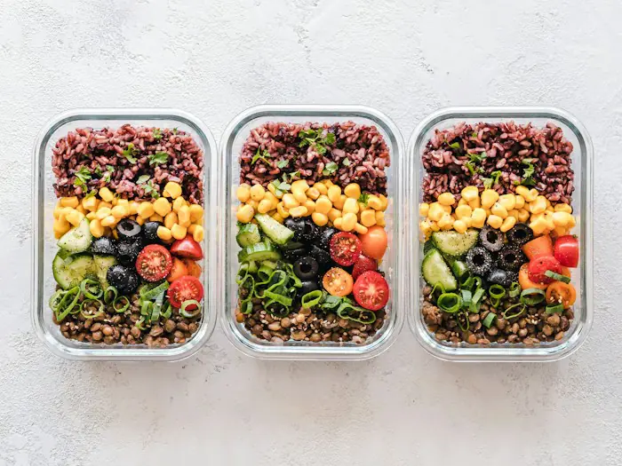 Bulgur, nohut, zeytin ve sebzelerle hazırlanmış üç cam saklama kabı